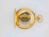 an image of a close up of a gold pocket watch on a white surface
