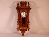 une horloge en bois accrochée au mur de la pièce