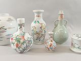 five vases and two jars sitting next to each other