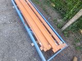 a wooden bench on the ground next to a wire fence