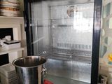 a glass case with a metal bucket inside of it