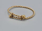 une photo d'un bracelet en or orné de deux petites perles