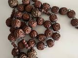 brown and white beaded necklace on a white surface with a silver clasp