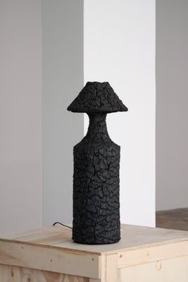 sculpture noire représentant un champignon posé sur une caisse en bois