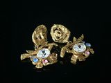 trois bijoux sont posés sur une surface noire