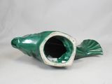 a green fish shaped vase sitting on a white surface