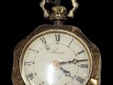 a gold pocket watch with roman numerals on the face
