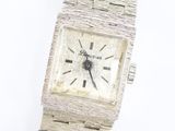 une image d'un gros plan d'une montre-bracelet sur une surface blanche