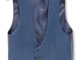 the blue vest is hanging on a hanger on the wall