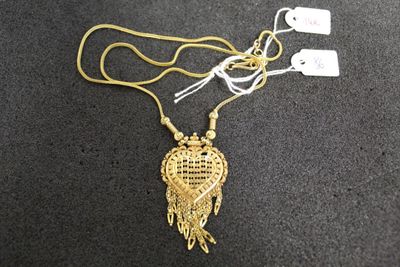 gold plated necklace with a heart shaped pendant on a gold chain