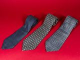 three ties on a red surface with a red background