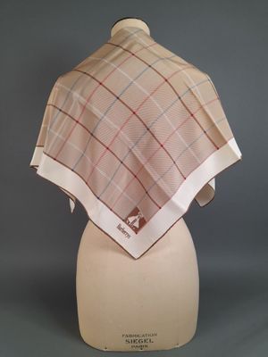 beige and red plaid shawl on a mannequin head