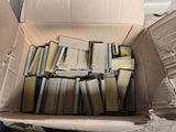 a cardboard box full of books sitting on the floor