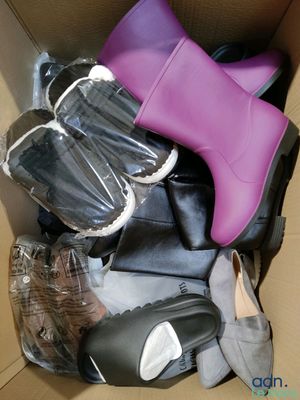 plusieurs paires de chaussures dans une boîte posée sur le sol