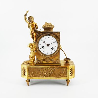une horloge en or surmontée d'une statue