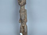 une vieille statue en bois d'un homme avec un chapeau sur la tête