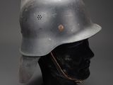 an old helmet on a mannequin head on a gray background