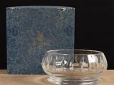 a glass bowl sitting on top of a table next to a book