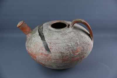 un vase posé sur une table, sur fond bleu