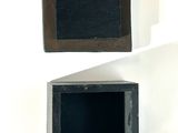 two black boxes that are sitting on a white surface