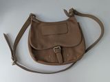 sac à main en cuir marron avec une bandoulière et des boucles sur un fond blanc