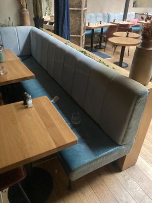 deux tables et un banc dans un coin d'un restaurant