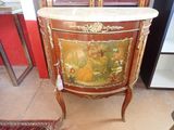 a cabinet with a painting on it in a room