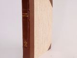 a book with a brown cover sitting on a white surface