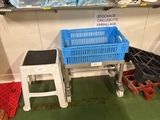 un panier bleu et un tabouret blanc dans une pièce