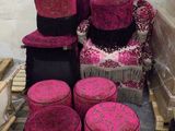 une pile de chaises et de tabourets roses et noirs