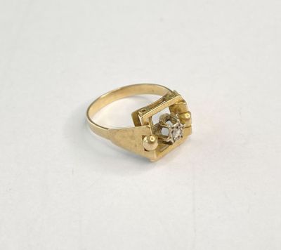 gros plan d'une bague en or sur une surface blanche