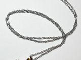 collier avec une pierre rose et une chaîne en argent sur fond blanc