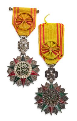 trois médailles sont présentées sur un fond blanc, accompagnées d'un ruban rouge et jaune