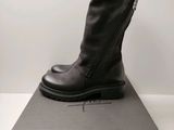 Les bottes noires sont posées sur la boîte, sur la table.