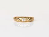 a yellow gold ring with a diamond in the center