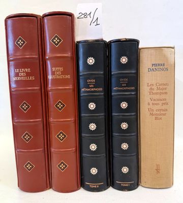 several books are lined up in a row on a white surface