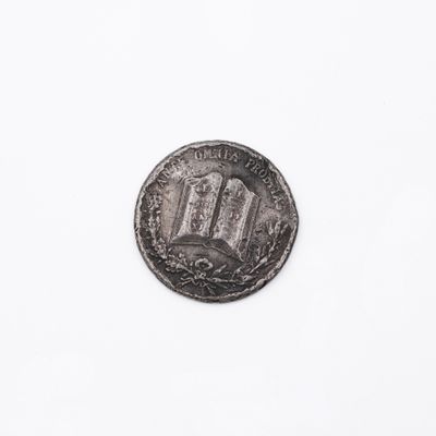 une pièce d'argent sur laquelle est représenté un bâtiment