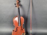 an old violin sitting next to a violin stick on a gray surface