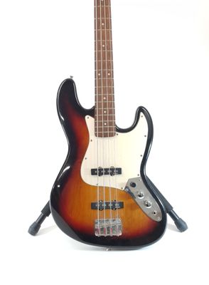 an electric bass guitar sitting on top of a stand on a white surface