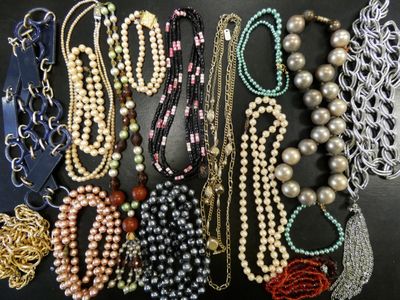 many different types of necklaces and bracelets laid out on a table