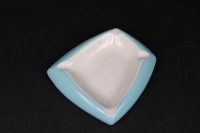 a small blue and white plate on a black table