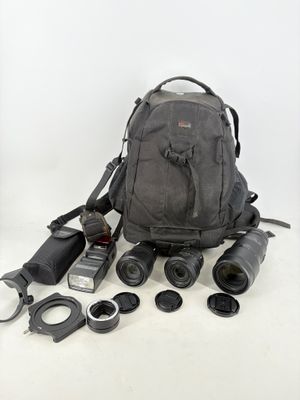 un sac à dos contenant un appareil photo, un objectif et d'autres objets