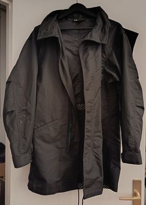 a coat hanging on the wall next to a chair