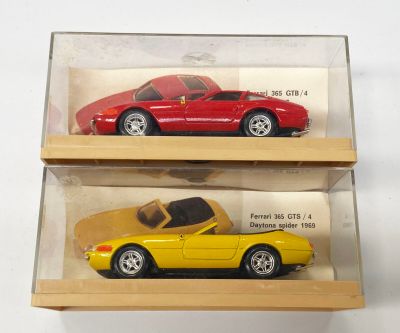 deux petites voitures dans une vitrine posée sur une table