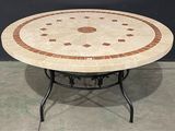 une table ronde avec un plateau en carrelage et un piètement en métal