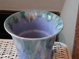 a blue vase sitting on top of a wicker chair