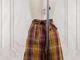 purple and yellow plaid skirt on mannequin dummy in front of a white wall
