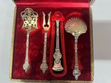 silverware in a red velvet box with gold trimmings and spoons