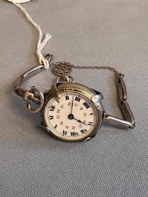 une montre à gousset en argent à laquelle est attachée une chaîne