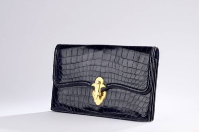 a black crocodile skin wallet with a gold lock on the front